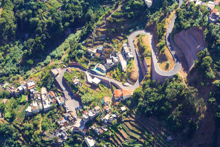Up view of little city with curved road in the mountainsの写真素材