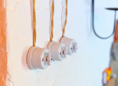Old electric wires with three switches on the wallの写真素材