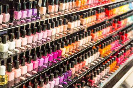 Set of different nail varnishes on shelves in cosmetic storeの写真素材