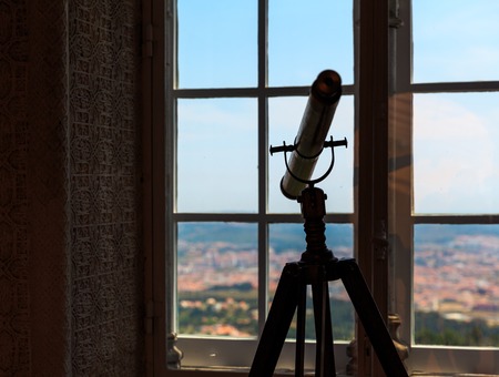 Silhouette of telescope stands in the room near the windowの写真素材