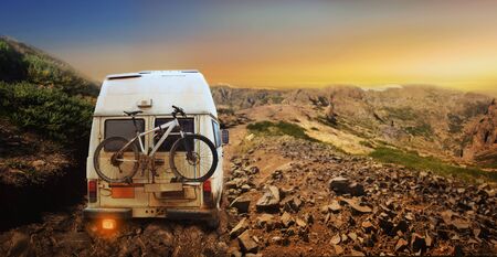 White truck with mountain bike in the mountain at sunsetの写真素材