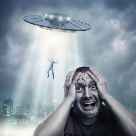 Scared by UFO man screaming at nightの写真素材