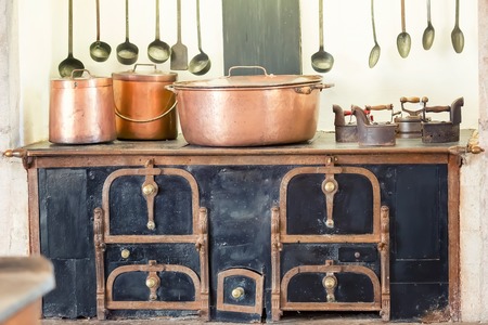 Retro kitchen interior with old pans, pot on the furnaceの写真素材
