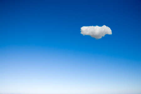 One little cloud on a clear blue skyの写真素材