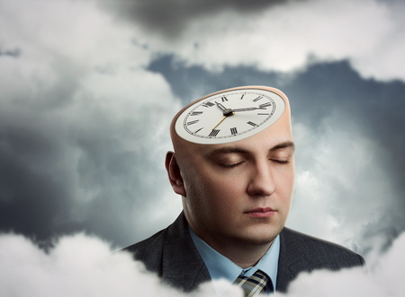 Businessman's head with clock instead of hairの写真素材