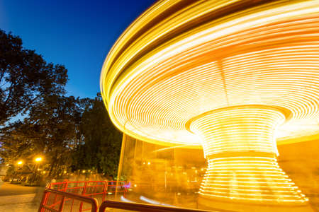 Fast merry-go-round lighting in the nightの写真素材