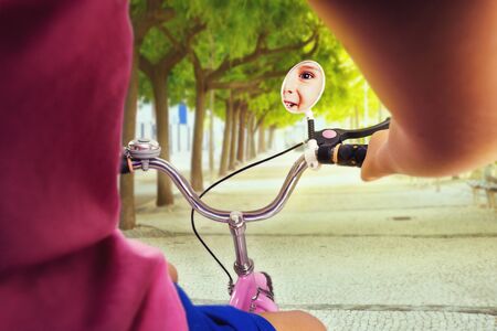 Cute little girl cycling on pink bike in the parkの写真素材