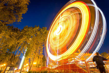 Fast big wheel in the night parkの写真素材