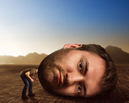 Man with enormous head in the desertの写真素材