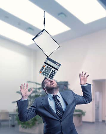 Businessman with stationery holding on his nose at office