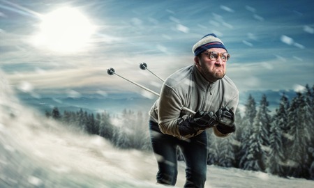 Bearded vintage skier in glasses skiing fast while snowingの写真素材