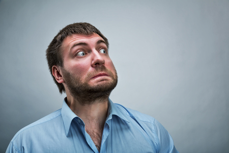 Frightened businessman wearing blue shirt over greyの写真素材