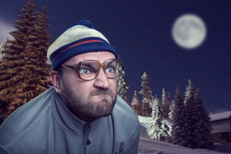 Bearded retro man in glasses in winter mountains at nightの写真素材