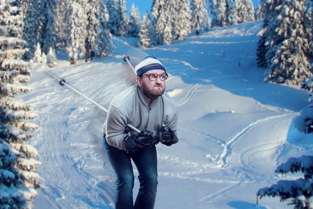 Vintage skier in glasses skiing fast while snowingの写真素材