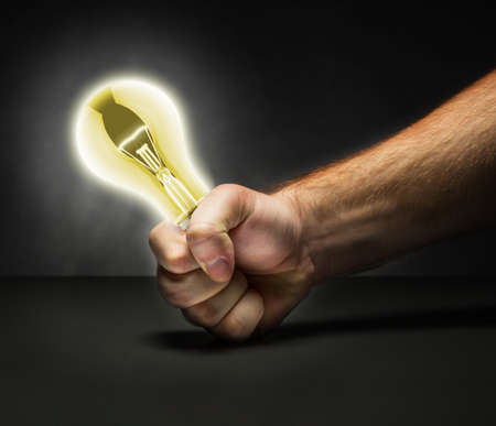 Strong male fist holding an enlighted lamp