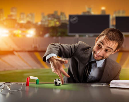 Businessman playing football with fingers on the football groundの写真素材