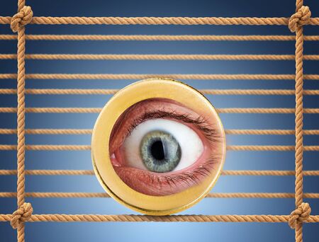Human eye in the coin over rope net backgroundの写真素材
