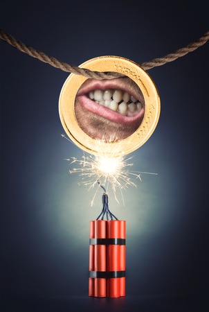 Human mouth in the coin hanging above the dynamiteの写真素材