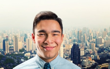 Smiling young businessman over the modern cityの写真素材
