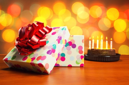 Birthday cake with candles and present-box on the table
