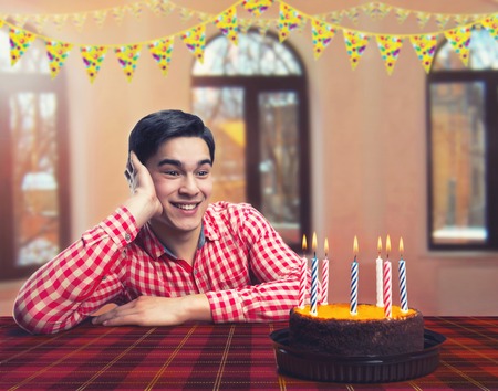 Happy birthday boy with cake in decorated roomの写真素材