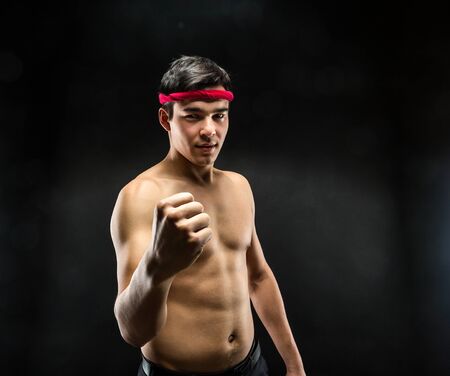 Young wrestle fighter standing over black backgroundの写真素材