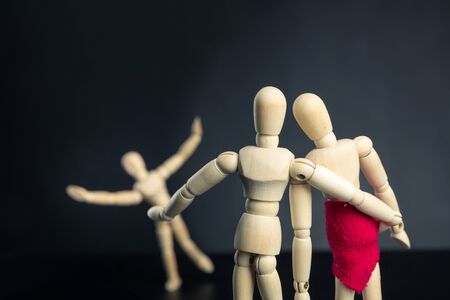 Family of wooden figures over black, child having funの写真素材
