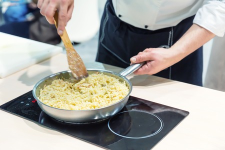 Cook cooking food on the pan close upの写真素材