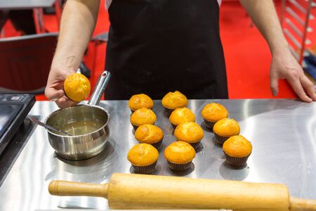 Man cooking tasty cakes in the bakeryの写真素材