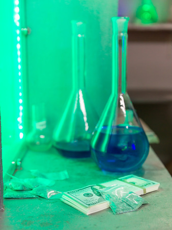 Meth, money, gas mask and flasks on the table in the labの写真素材