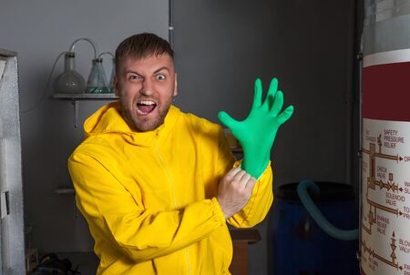 Man in protective outerwear suit wearing rubber gloves preparing to cook methの写真素材
