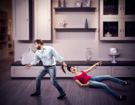 Angry man pulling woman by the hair at homeの写真素材