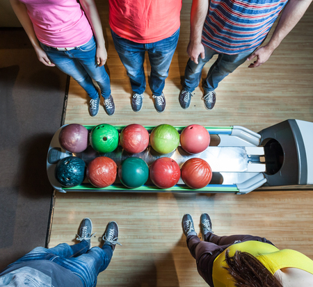 Up view of people in bowling standing near ballsの写真素材