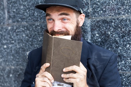 Close up portraiit of excited vagrant biting book pagesの写真素材