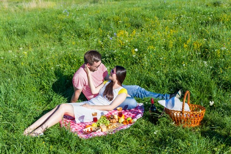 Young loving couple having picnic on the meadowの写真素材