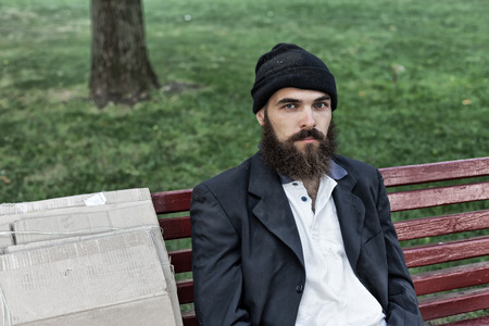 Bearded vagrant sitting on the benchの写真素材