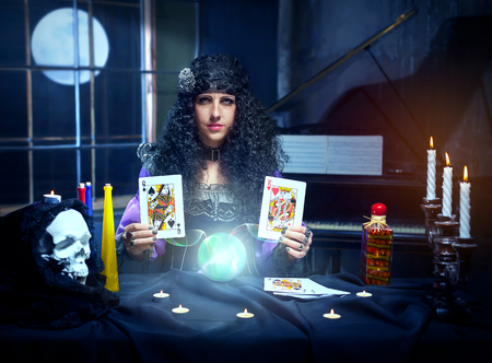 Sorceress working with cards and crystal ball in her room, crystal ball is glowing
