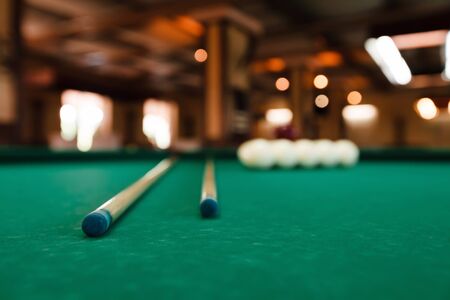 Billiard balls and pool sticks on the green table
