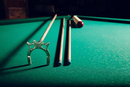Billiard balls and pool sticks on the green table