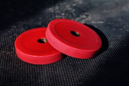 Red weight plates on the floor in the gymの写真素材