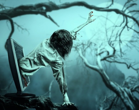 The corpse woman gets out of the computer monitor against the background of the moon and daed tree. Halloween.の写真素材