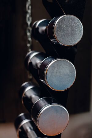 Heap of black dumbbells with weight plates on the rackの写真素材