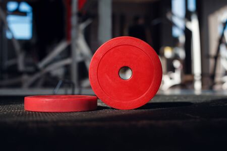 Red weight plates on the floor in the gymの写真素材