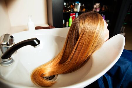 Yuong female making hair care procedure in hairdressing salon.の写真素材