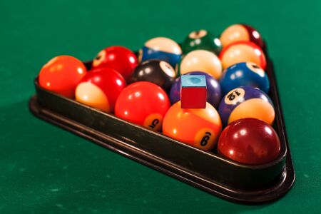 Balls in a pool triangle on the table. Green cloth.