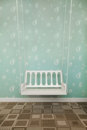 Room studio with white teeter on ropes and carpet on the floor. Childish design concept .の写真素材