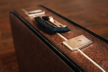 Closed retro suitcase on the wooden floor. Vintage travel concept.の写真素材