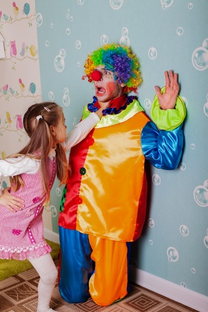 Cruel girl playing with scared clown at her birthday partyの写真素材