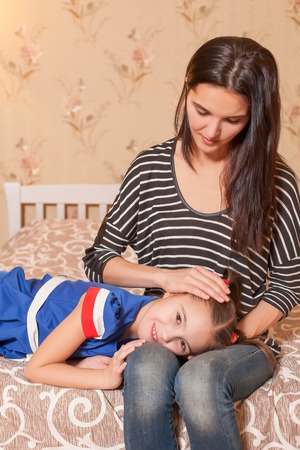 Pretty daughter lies on a laps of her mother.の写真素材