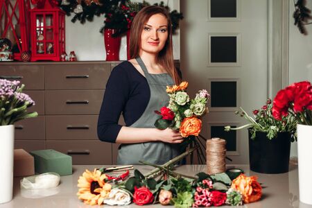 Female florist working with flowers while she made decorative bouquetの写真素材